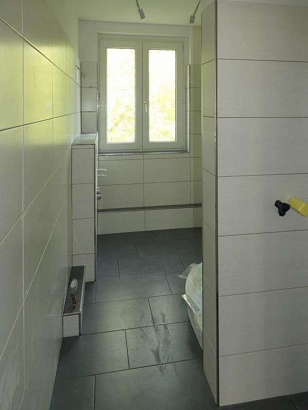 Auf dem Bild blickt man in ein Bad. Das Bad wurde umgebaut und saniert. Jetzt gibt es hier eine Dusche ohne Stufe.