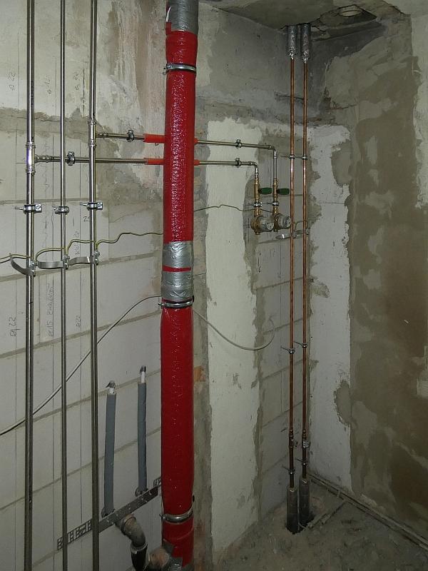 Das Bild zeigt vermauerte Wanddurchbrüche. An der Mauer wurden Rohre angebracht. Die Rohre gehören zu einem Bad. Das Bad wir gerade neu gebaut.