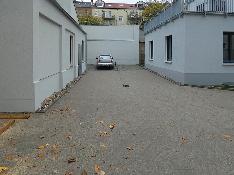 Das Bild zeigt einen Innenhof. Der Innenhof wurde neugestaltet. Es wurden Stellplätze für PKW gebaut. Der Innenhof gehört zum Hinterhaus in der Kantstraße. Das Hinterhaus heiß Südterrassen.
