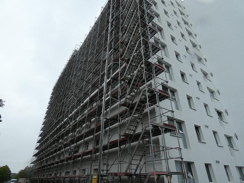 Das Bild zeigt ein Wohnhaus. Am Wohnhaus gibt es kein Gerüst mehr. Jetzt sollen an dem Wohnhaus Balkone angebaut werden. Die Balkone werden Rettungsweg.