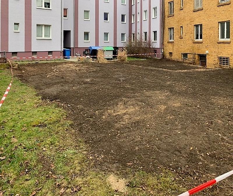 Das Bild zeigt einen Innenhof. Im Innenhof wurden Sträucher weggemacht. Der Innenhof gehört zu einem Wohnhaus. Das Wohnhaus steht in Delitzsch.