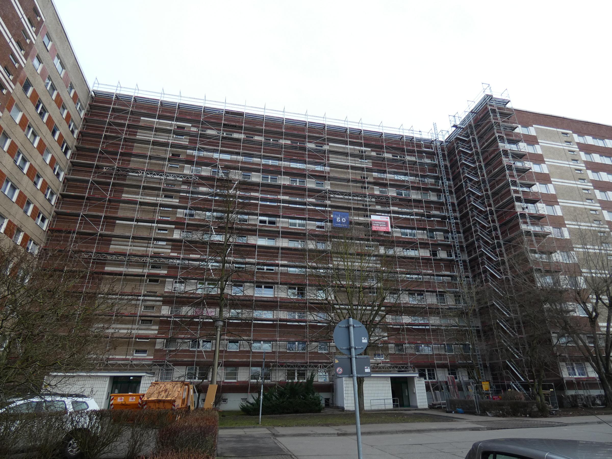 Das Bild ziegt eine vollständig eingerüstete Fassade an einem Mietwohnhochhaus.