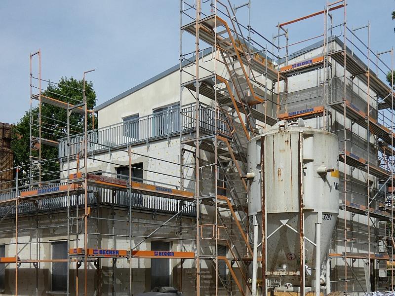 Das Bild zeigt ein Haus. Vor dem Haus steht ein Gerüst. Die Fassade wird geputzt. Die Arbeiten sind fast fertig.