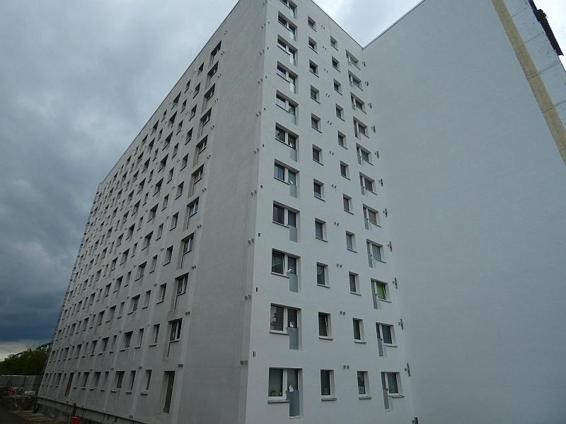 Das Bild zeigt eine Fassade. Die Fassade wurde wärmegedämmt. An der Fassade fehlen noch die Balkone. Die Balkone werden auch Rettungsweg.