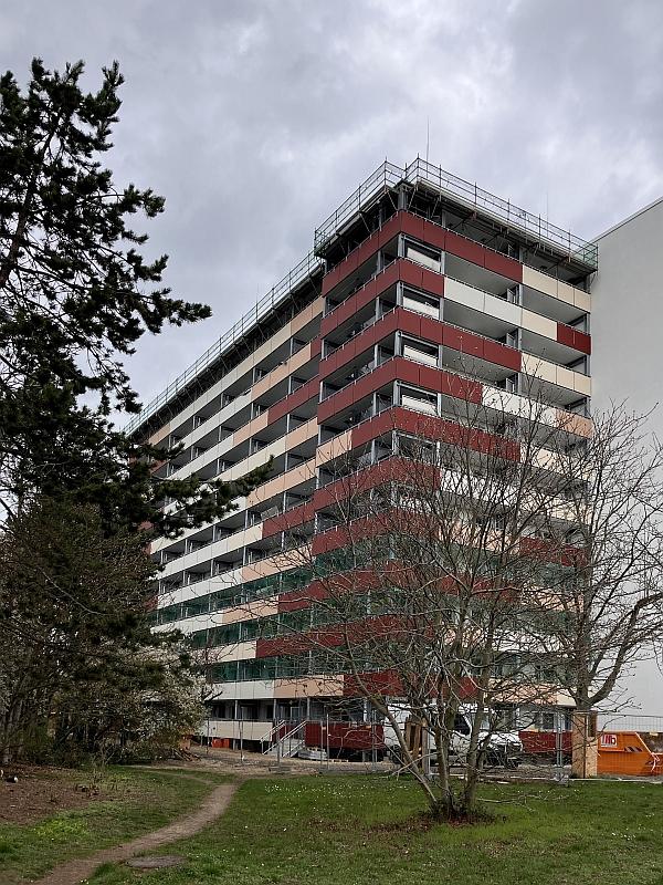 Das Bild zeigt ein Wohnhaus. Am Dach vom Wohnhaus wird gearbeitet. Das Wohnhaus steht in Grünau.