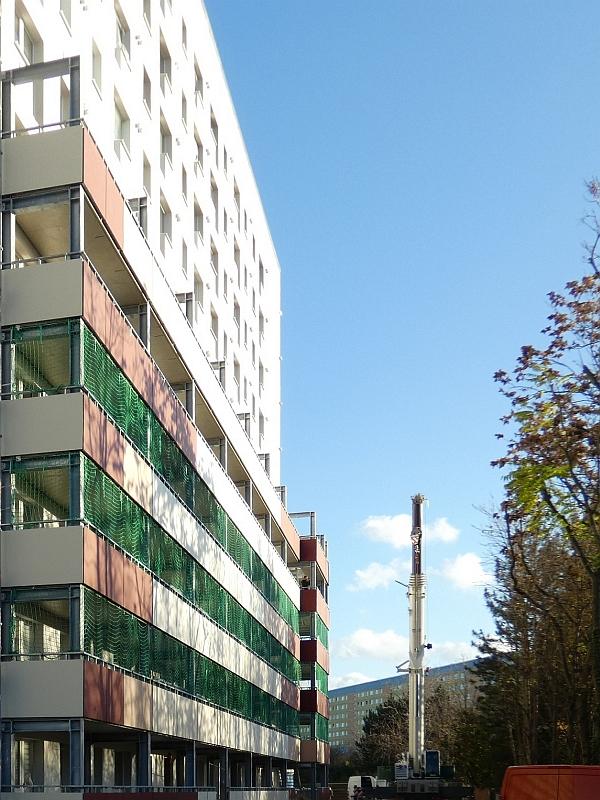 Das Bild zeigt ein Hochhaus. Am Hochhaus werden Balkone angebaut.