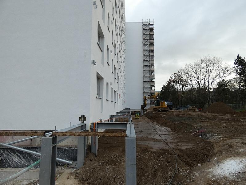 Das Bild zeigt ein Wohnhaus. Am Wohnhaus werden Balkone angebaut. Der Unterbau steht schon. Das Wohnhaus ist in Leipzig Grünau.