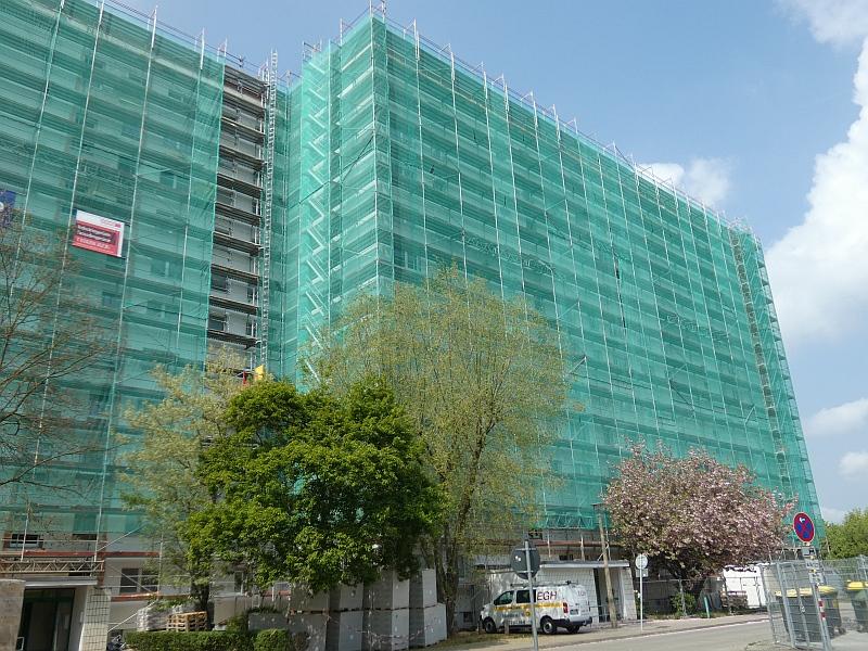 Auf dem Bild sieht man ein eingerüstetes Hochhaus. Am Haus wird die Fassade saniert.
